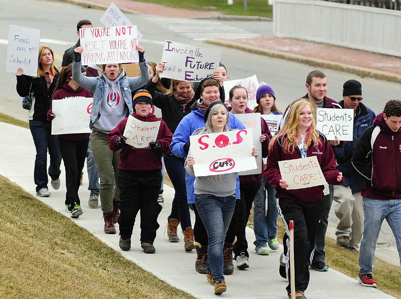 Students march along Capital Street between State House and Blaine House during a protest on Friday at the State House in Augusta.