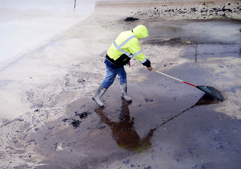 Augusta Parks, Cemeteries and Trees employee Gus Gosselin rakes the bottom of the Calumet Playground pool Tuesday in Augusta, clearing debris that collected during the winter. City crews are prepping three pools for swimmers when school is released this summer.