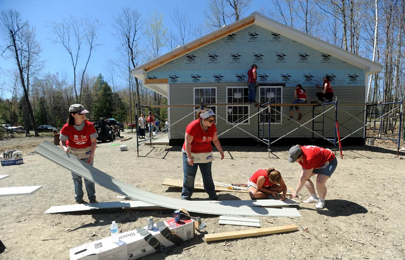 Tina Cook, far left, Khristina Thayer, left center, Kelsey Atwood, right center and Alice Stinson measure vinyl siding during the Lowe's Women Build Day at the Habitat for Humanity house on Jaques Lane in Oakland on Saturday. About 30 women volunteered their skills and sweat for the day, making up nearly 75 percent of the workforce at the job site.