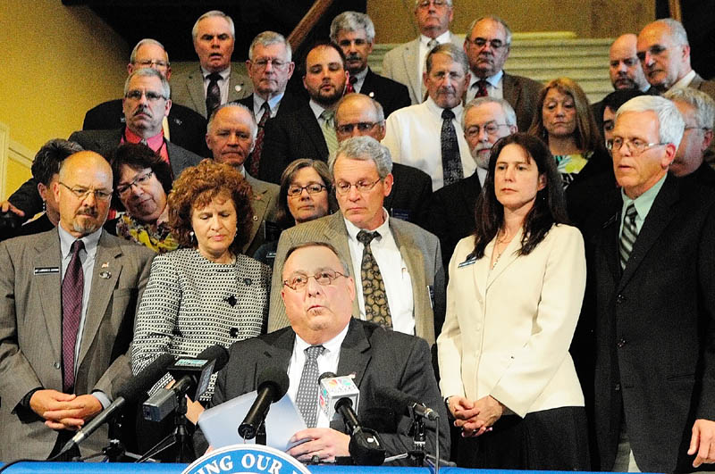 Moments after it was passed, Gov. Paul LePage reads his veto message of L.D. 1546, "An Act To Strengthen Maine's Hospitals, Increase Access to Health Care and Provide for a New Spirits Contract," in the Hall of Flags on Thursday in the State House in Augusta.