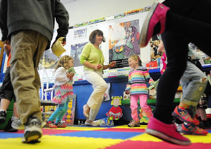 Teacher Karen Toothaker, center, leads her students as the sing and dance along to a recording of "The Bean Bag Alphabet Rag" during a pre-kindergarten class at Manchester Elementary School in this 2014 file photo.