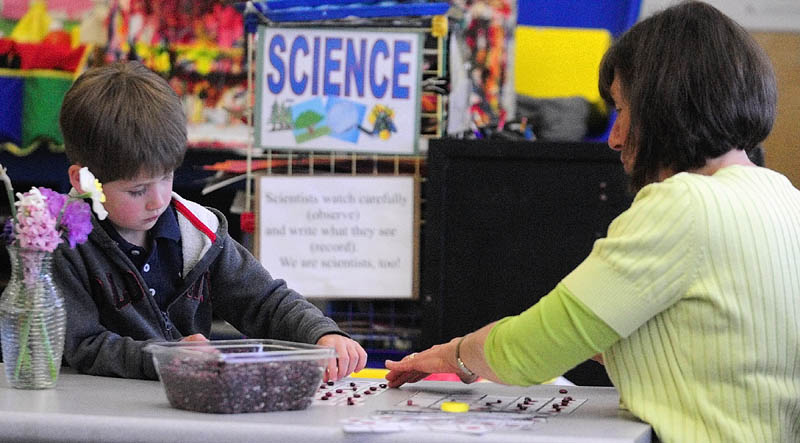 Joey Dumulin and teacher Karen Toothaker count beans recently during a pre-kindergarten class at Manchester Elementary School.