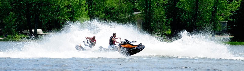 Christopher Carron, left, of Vassalboro, and Josh Dyer, of Benton, take a spin on their personal water crafts on Thursday in China Lake in China. It was a warm and sunny day, but the water was still cold.