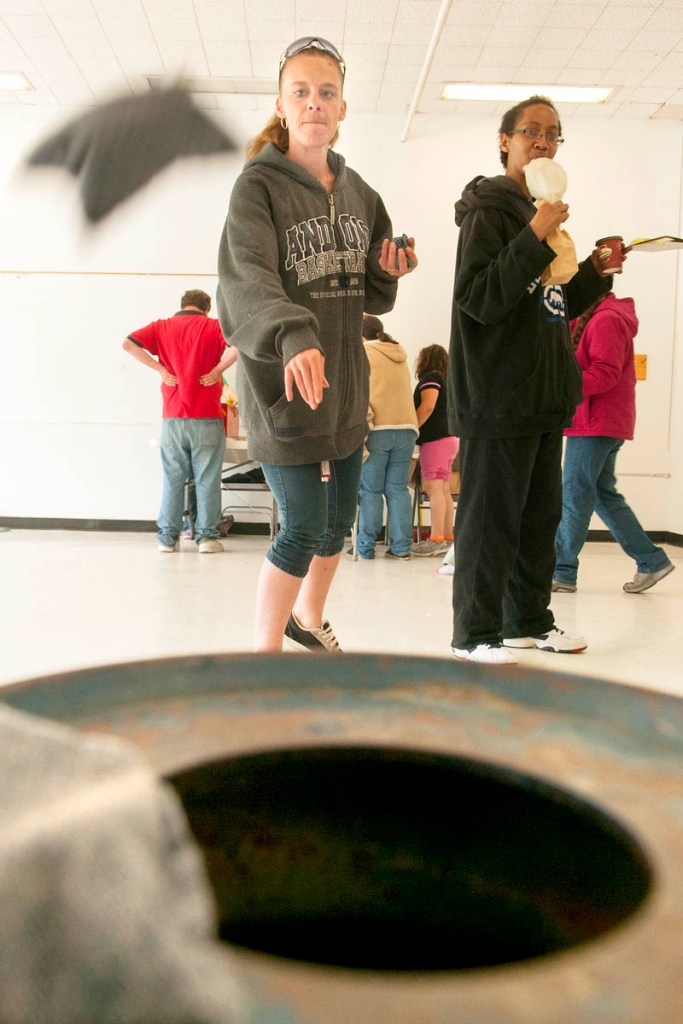 Sandra Watson tosses bean bags into a milk can during the Kennebec Community Church's Memorial Weekend Block Party on Sunday at the Buker Center in Augusta. The event was supposed to be outdoors, but the carnival games, food booths and bounce houses were moved inside the building because of the rainy weekend weather.