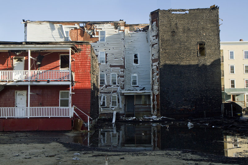 Buildings stand in the aftermath of a massive fire at Bartlett and Pierce streets in Lewiston. Firefighters poured so much water onto the roofs of both buildings on Pierce Street that torrents of water cascaded out windows and doors and into the streets.