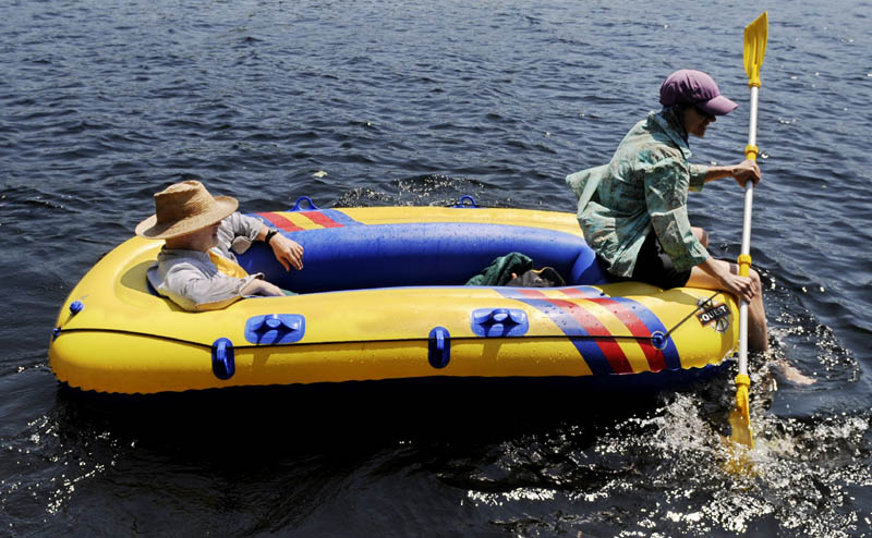 Tom Swann surveys Minnehonk Lake as Susan Melcher paddles a raft Sunday near their home in Mount Vernon. The couple was working in the garden when high temperatures compelled them to flee to the water, according to Melcher. "It is hot, hot, hot in the garden," she reported.