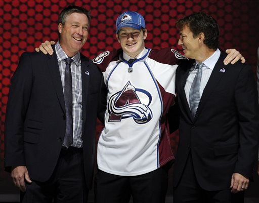 Nathan MacKinnon stands with officials from the Colorado Avalanche sweater after being chosen No. 1 overall in the first round of the NHL draft on Sunday in Newark, N.J.