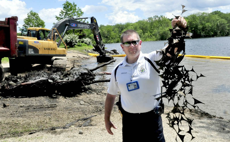 Oakland police Detective Tracey Frost holds up some metal that was dredged from the bottom of Messalonskee Lake at the boat landing on Monday. After the town and the Friends of Messalonskee applied for permits, contractor William Mushero & Sons dredged 2 feet of lake bottom, where a bean cannery dumped tons of unwanted metals 100 years ago, according to Frost. He said the metal has been working up from the bottom, causing minor injuries. Stones will be poured over the dredged site later this week. "This will be a safer and cleaner area," Frost said.