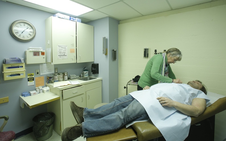 A nurse practitioner at the India Street Public Health Clinic in Portland examines a patient.