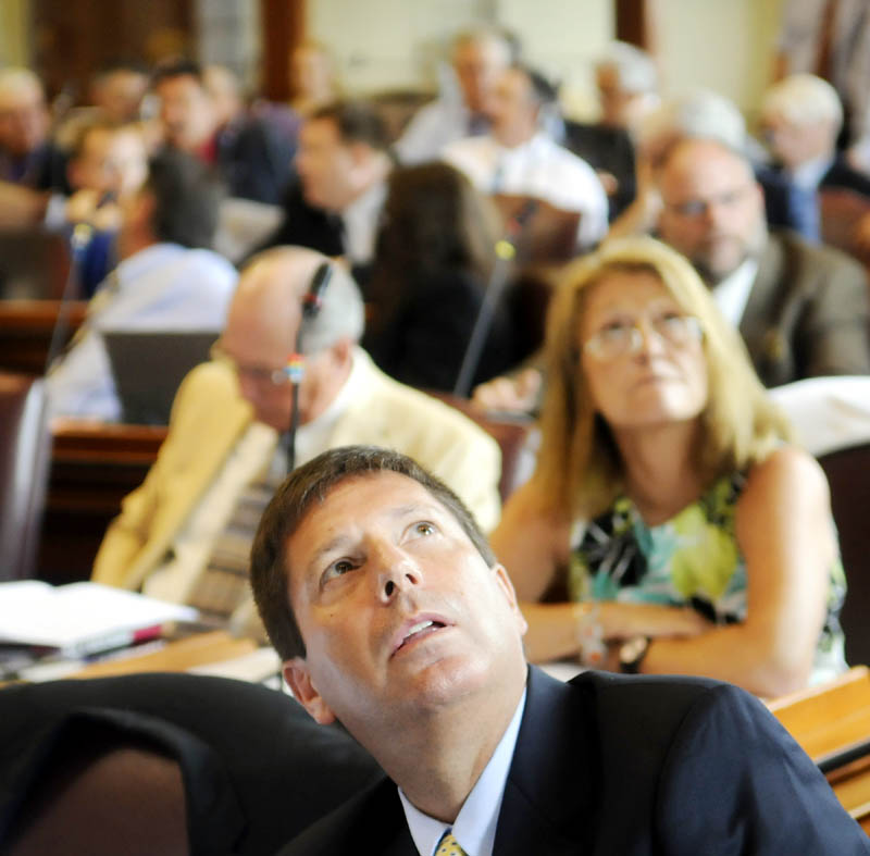 Minority Leader Rep. Ken Fredette, R-Newport, center, watches the tote board Tuesday in the House of Representatives, during consideration of overriding several vetoes issued by Gov. Paul LePage.