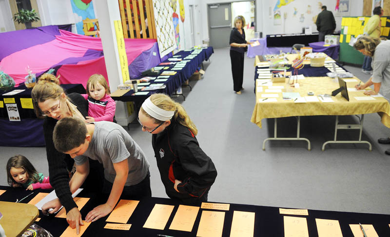 Folks browse some of the hundreds of items up for auction and sale during the silent bidding Tuesday at the Wayne Community Church. The four day auction will raise money for the church and charities.