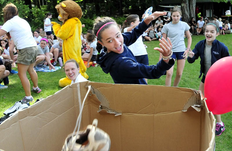 Camp Runoia camper Charlotte Westermann does a backward dunk of a pair of sneakers during a "Dunk Your Kicks" event in Belgrade on Wednesday. Children donated 90 pairs of sneakers as part of the Max Cure Foundation and Maine Camp Experience collaboration. The footwear will be sent to developing nations. Camp Runoia owner Pam Cobb said the children learned about social action and sent a message of hope. "They also kept the sneakers out of a landfill," Cobb said.