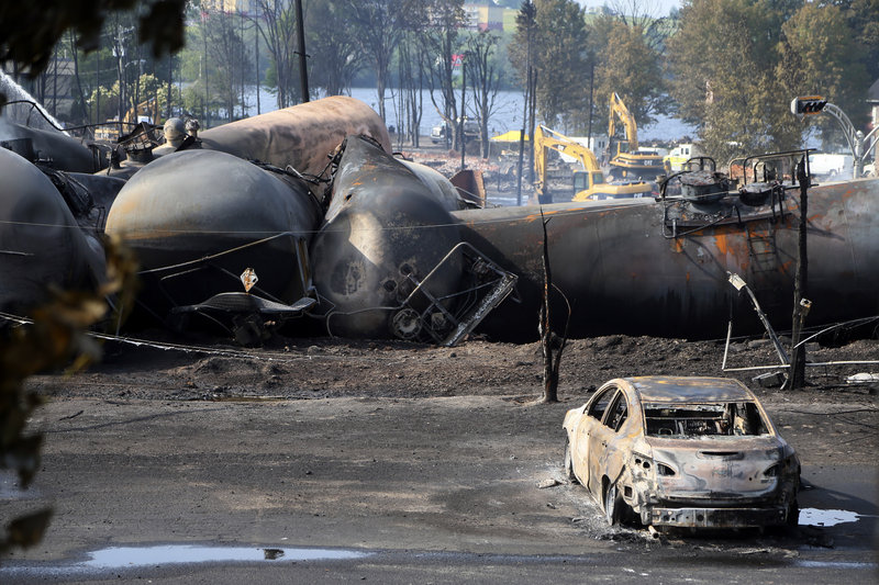 A burnt out vehicle sits near the wreckage of a train car following a train derailment in Lac Megantic Quebec.