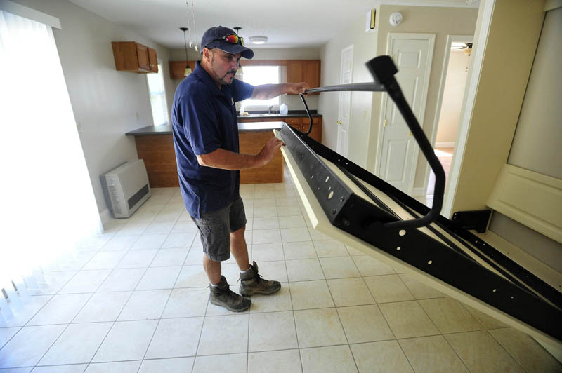 Andy Vear, a local real estate developer, shows the Murphy pull -out bed for guests in the combined kitchen, dining and living area at his 20 Cool St. microhome in Waterville on Tuesday. The main bedroom is behind the door to the right, and next to that is a full bathroom.