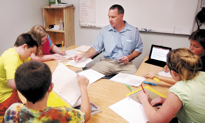 Fifth-grade teacher Michael Louder works in a small group with students at Canaan Elementary School during a reading workshop May 31. The school was one of two in Skowhegan-based School Administrative District 54 that Department of Education Commissioner Stephen Bowen visited that day. The school received a B grade under Gov. Paul LePage's A-F school grading system.