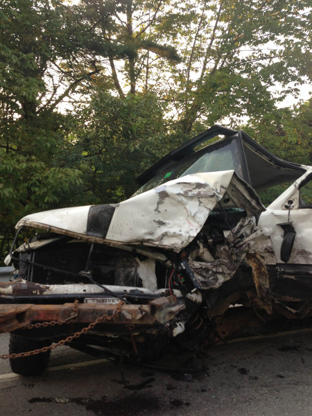 One of the two pickup trucks damaged in a double-fatal head-on collision on Riverside Drive in Vassalboro today is hooked up to a wrecker.