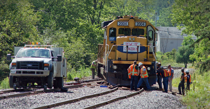 A derailed Montreal, Maine & Atlantic Railway train displays a "remote control" sign Wednesday in Brownville. Trains carrying a single engineer must display the sign and they sometimes are operated by remote control.