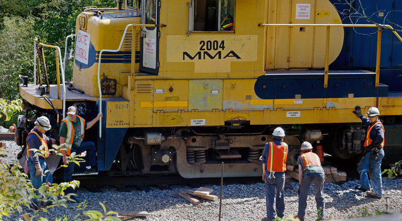 A crew from Montreal, Maine & Atlantic Railway repairs tracks in Brownville on Wednesday. None would talk about the local effects of the deadly Quebec disaster of July 6.