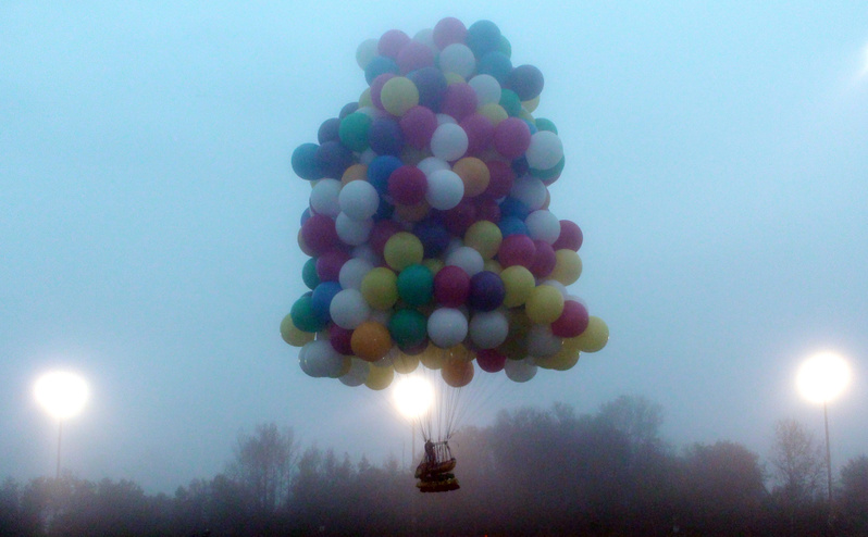 A balloon cluster carrying Jonathan Trappe lifts off from Caribou on Thursday. Unlike a conventional hot-air balloon, Trappe is relying on hundreds of helium-filled balloons clustered together.