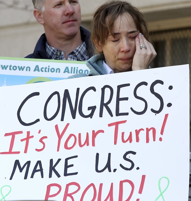 In a Friday, April 5, 2013 file photo, Newtown, Conn., resident Jennifer Killin wipes tears on the steps of Hartford, Conn., City Hall, during a rally to urge passage of federal legislation to curb gun violence. Activists from Newtown, where 26 people were gunned down in a mass shooting at an elementary school in December 2013, headed to Washington on Tuesday, Sept. 17, 2014 to lobby again for gun control. The trip was planned to mark roughly nine months since the Dec. 14 rampage, but took on new urgency in the wake of the massacre in the capital that killed 13 on Monday. (AP Photo/Journal Inquirer, Jared Ramsdell, File) MANDATORY CREDIT