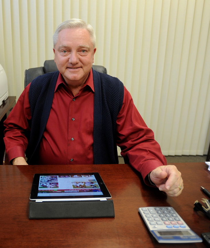 Up Late: David Smith, branch manager for Raymond James Financial Services in Waterville, relaxes Thursday in his office after staying up late to watch the Red Sox win the World Series.