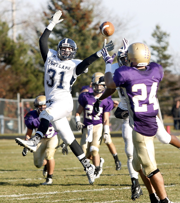 Tim Greenway/Staff Photographer Portland High School's Joe Esposito looks back as Cheverus High School's Noah Stebbins catches the ball in the third quarter at Cheverus High School during the Eastern Class A football championship game in Portland on November 16, 2013.