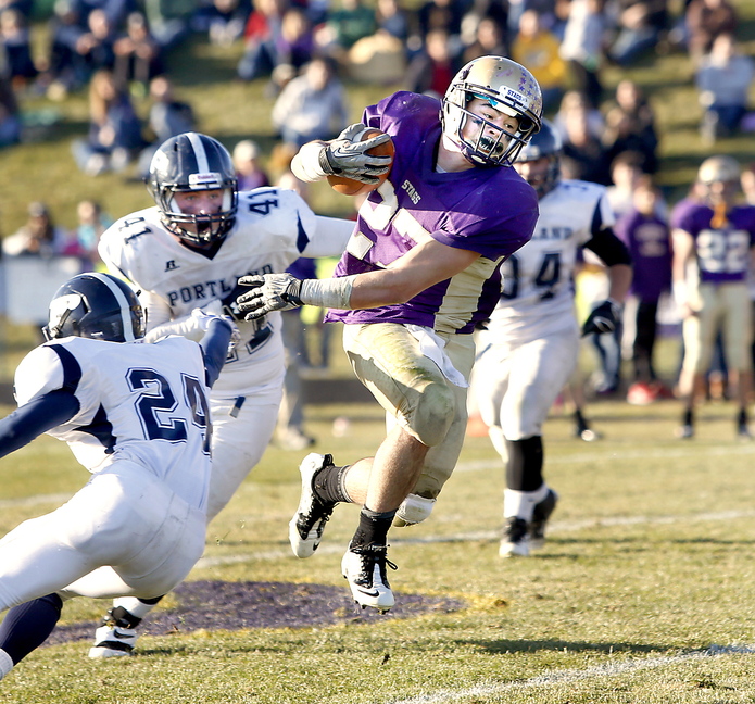 Tim Greenway/Staff Photographer Joe Fitzpatrick of Cheverus High School avoids the tackle of Portland High School's Alex Oja in the fourth quarter during the Eastern Class A football championship game in Portland on November 16, 2013.