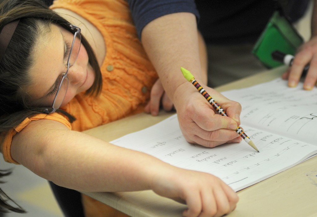 NECESSARY SKILL: A Chelsea Elementary third-grader, Jolie Canwell, works with teacher Rhonda Rush on a cursive lesson in which students learn to write the letter “r.”