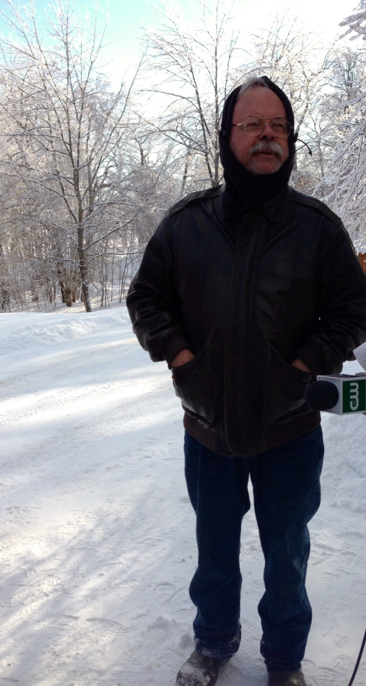 HOMEOWNER: Neil Farrington watches crews battle the fire at his house at Fire Road 14 Friday morning.