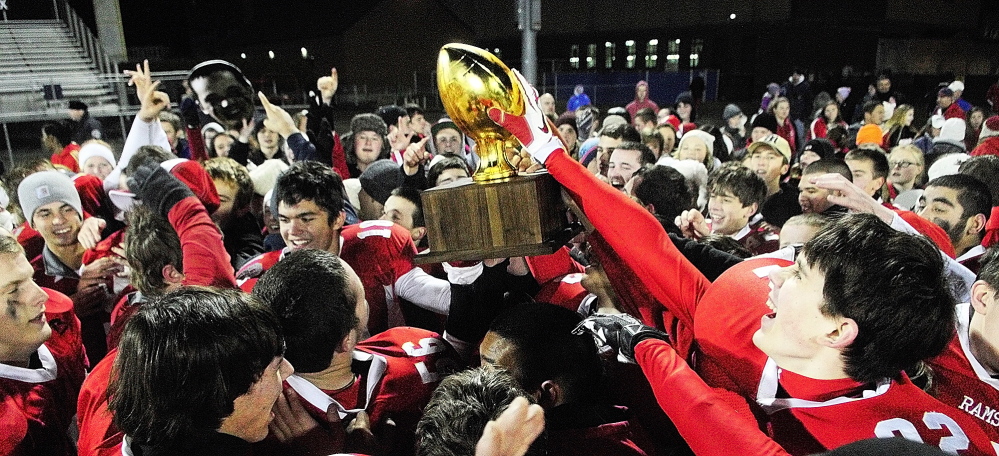 Staff photo by Joe Phelan Cony Rams players and their fans celebrate with gold ball trophy after beating Kennebunk to win the state class B football championship game on Friday November 22, 2013 in Orono.