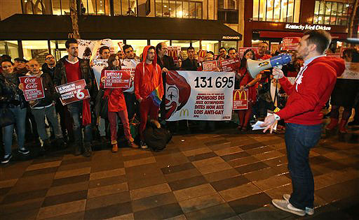 Gay rights activists demonstrate in front of a restaurant in Paris on Wednesday to protest Russia's policy over gay rights. Signs read: No to anti-gay law.