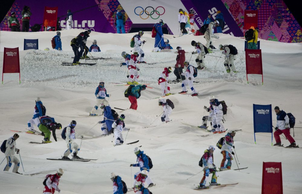 Athletes take part in a moguls course inspection Wednesday prior to a freestyle skiing training run at the 2014 Sochi Winter Olympics in Krasnaya Polyna, Russia.