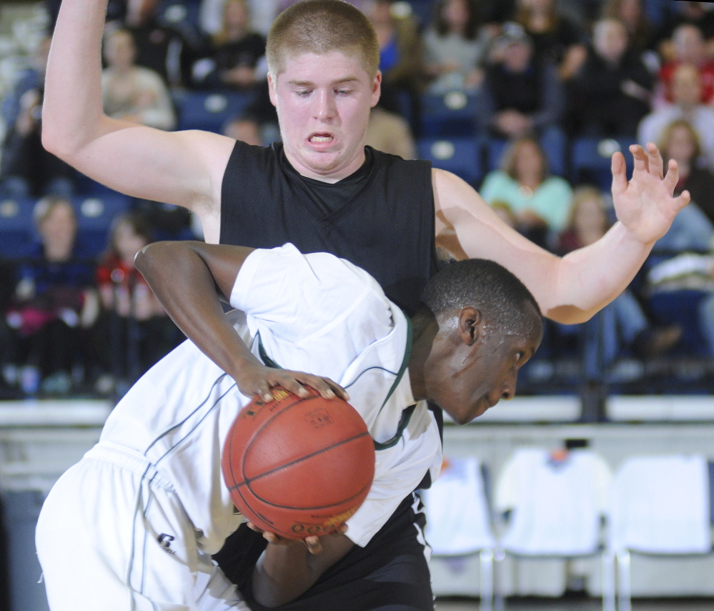 Staff photo by Andy Molloy Hall-Dale High School's Brian Allen blocks Waynflete School's Serge Nyirikamba during a tournament match up Thursday in Augusta.