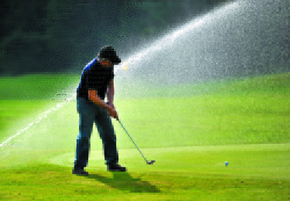 ON THE GREEN: David Bolduc concentrates on his putt on the second green as the sprinklers fire behind him at Pine Ridge Golf Course on West River Road in Waterville in this 2011 file photo.