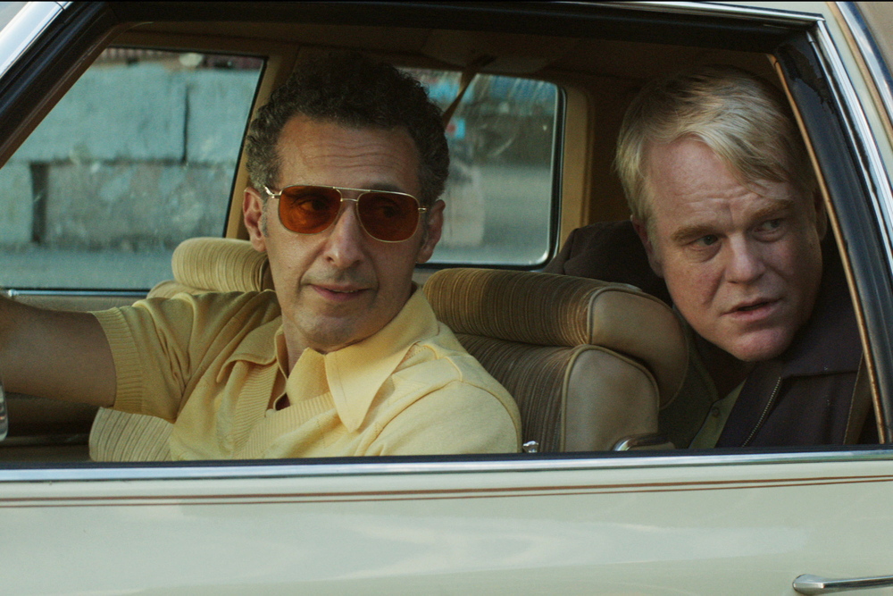 GOD'S POCKET - 2014 FILM STILL - John Turturro and Philip Seymour Hoffman (Mickey Scarpato) - Photo Credit: Lance Acord/IFC Films