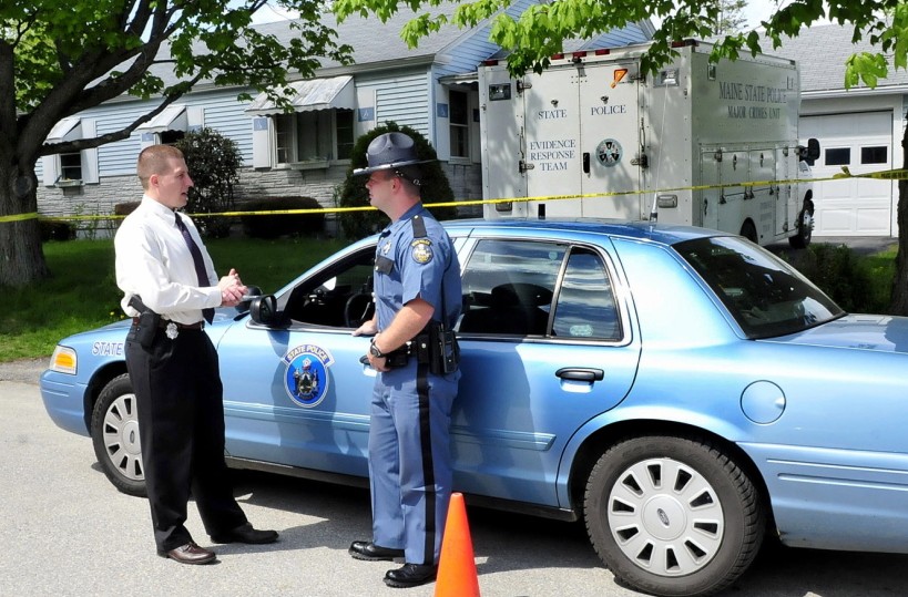 INVESTIGATION: Maine State Police Detective Sgt. Jeffrey Love, left, and trooper Randy Hall confer on Monday as investigators continue to search for evidence inside the Brooklyn Avenue home of Aurele Fecteau in Waterville.