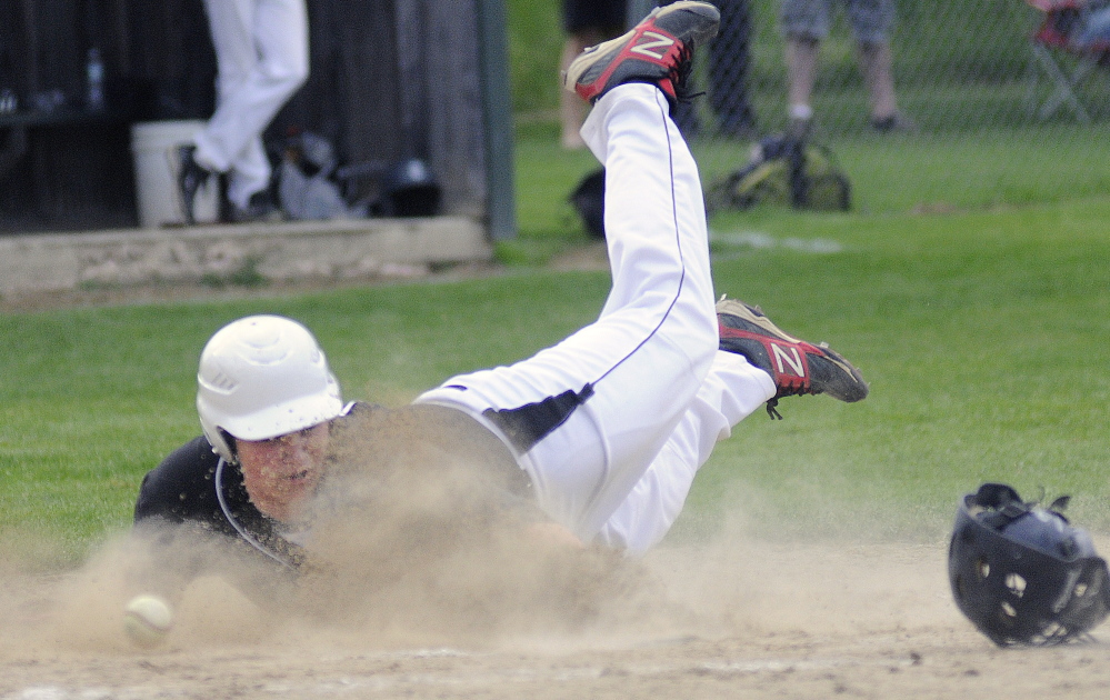 Staff photo by Andy Molloy COMING HOME: Hall-Dale High School’s Taylor Lockhart slides into home plate ahead of the throw Tuesday against Traip Academy.