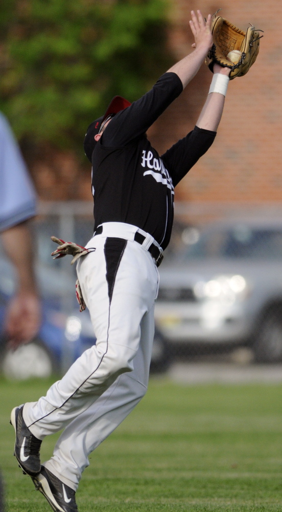 Staff photo by Andy Molloy IN THE AIR: Hall-Dale High School’s Alex McPherson snags a popper Tuesday June 10, 2014 behind first during a baseball match up against Traip Academy in Farmingdale.