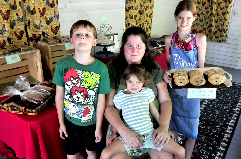 Jenny McLean sits with some of her children who help at the McLean Family Farm and Bakery in Winslow.