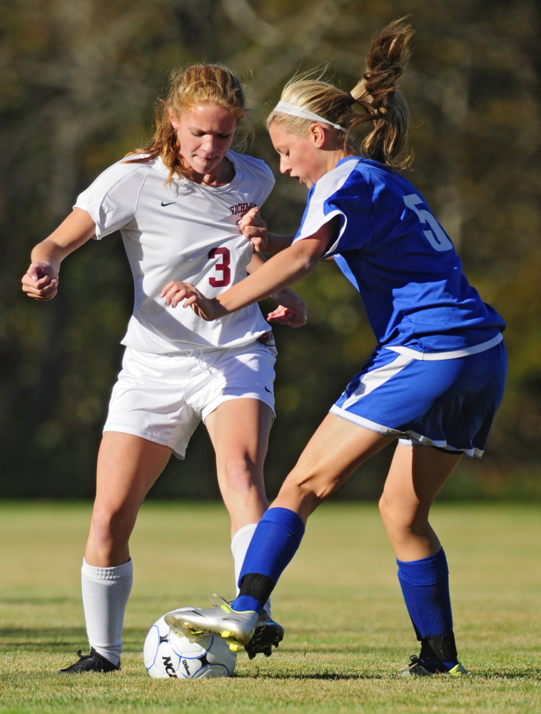 Richmond’s Molly Meagher, left, tries to move the ball up the field as Sacopee’s McKenzie Murphy grabs her jersey while trying to stop her during a game on Thursday at Richmond High.