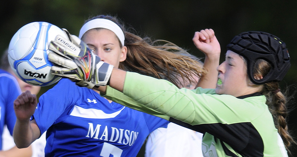 Monmouth Academy’s Maddie Neal snags the ball from  Madison Area Memorial High School’s Sydney LeBlanc Monday in Monmouth.