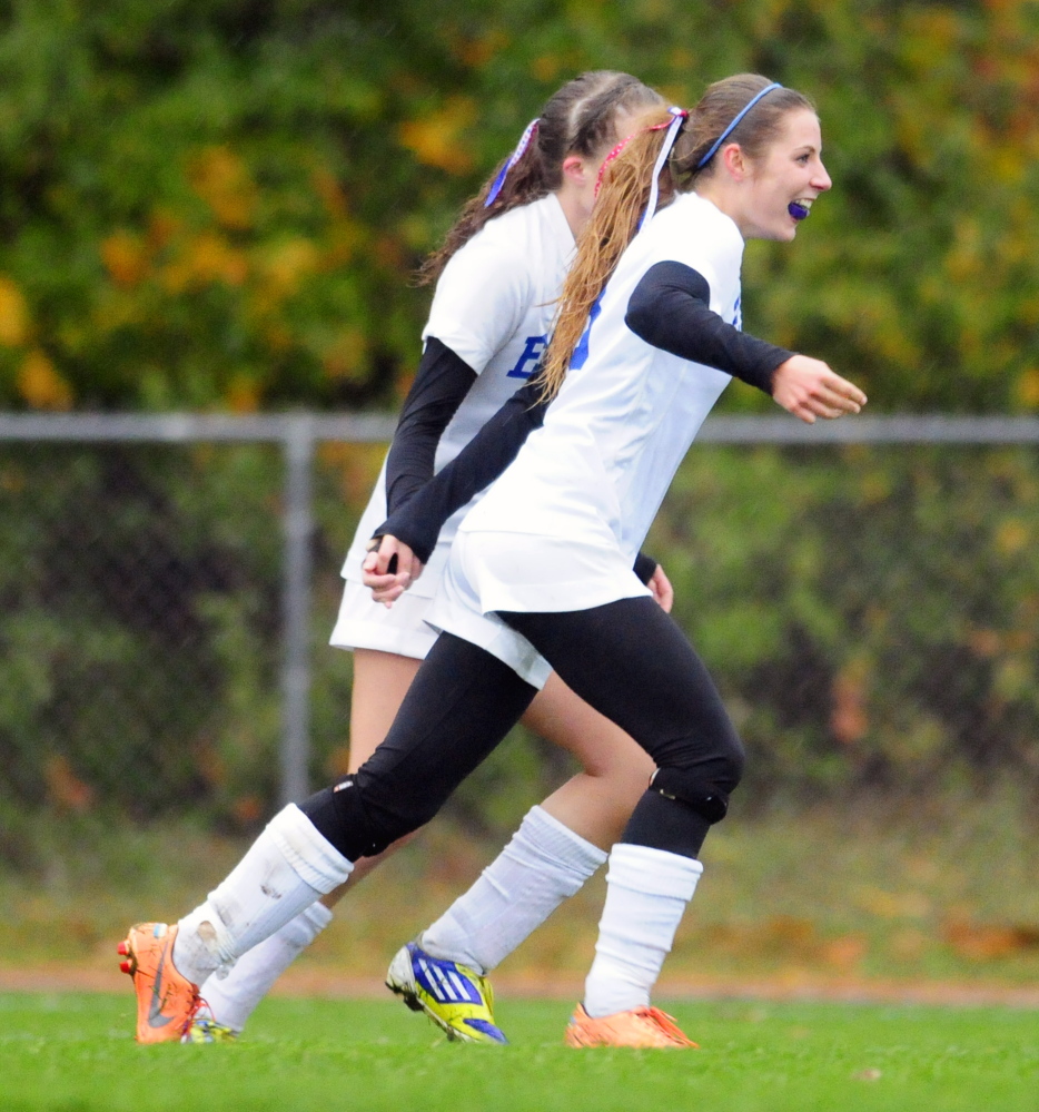 Erskine Academy striker Christina Belanger, background, congratulates teammate Taylor Boucher after Boucher scored a goal during the first half Tuesday in South China.