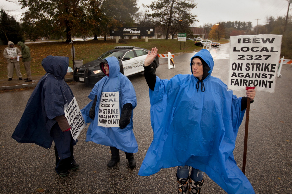 Susan Baron, at right, a FairPoint Communications worker, waves to a passing motorist Thursday as she pickets outside the FairPoint building in Portland with, at left, Brooke Blake and Julie Dubail, fellow International Brotherhood of Electrical Workers members. The workers are accusing FairPoint of negotiating in bad faith on a new labor contract.