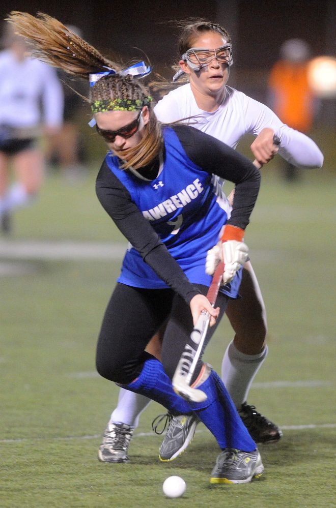 Lawrence High School’s Lilla Tilton-Flood (9) battles for the ball with Skowhegan Area High School’s Cassidy Clement (12) in the first half Thursday of the Eastern Class A title game at Hampden Academy.