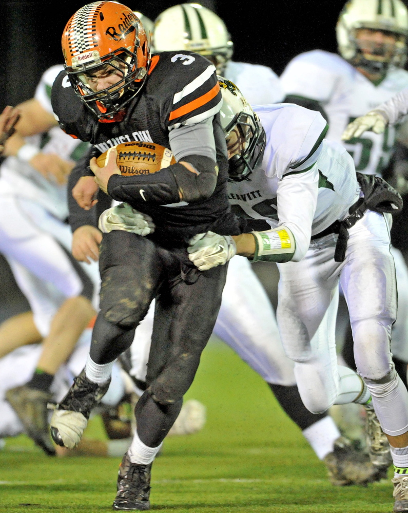 Staff photo by Michael G. Seamans 
 Winslow High School running back Dylan Hapworth (3) gets wrapped up by Leavit's Max Green in the first half of the Class C state title game Friday night at the University of Maine at Orono.