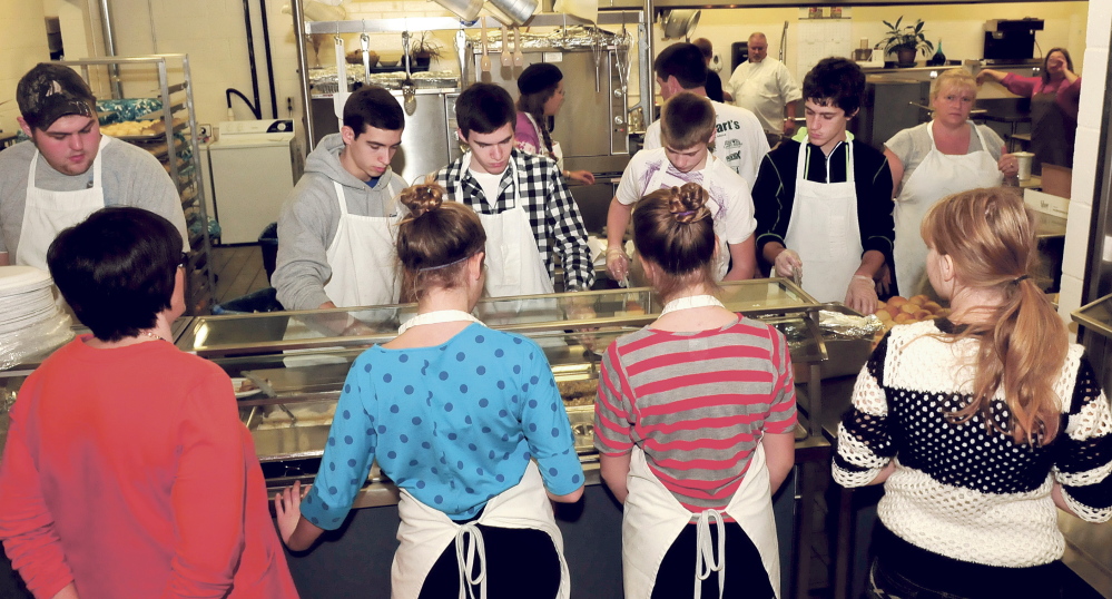 Volunteers dish out Thanksgiving dinners Thursday to drivers and servers during the annual Thanksgiving dinner held at Messalonskee high School in Oakland.