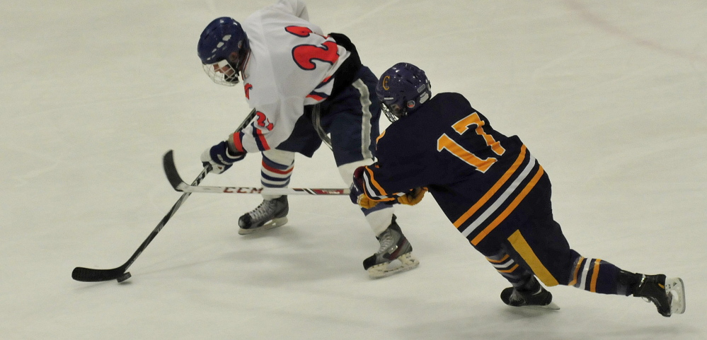 Lawrence/Skowhegan forward Brady Martin skates past Cheverus’ James Hannigan during a Class A crossover game Wednesday at Sukee Arena.