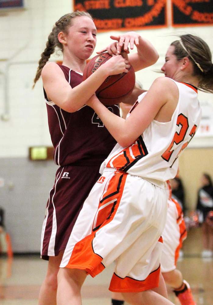 Maine Central Institute’s April McAlpine, left, wrestles for control of the ball with Winslow High School’s Delaney Wood during the first half of an Eastern B game Friday night in Winslow.