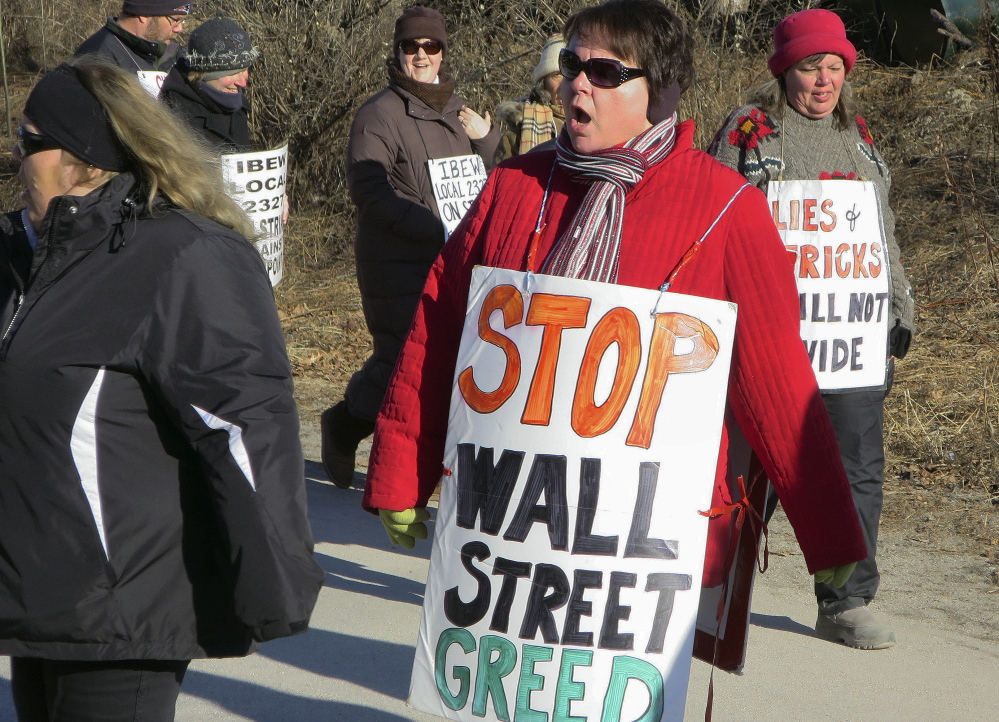 FairPoint workers walk a picket line Tuesday outside the company’s state headquarters at 5 Davis Farm Road in Portland. They hope to force the company back to the bargaining table.