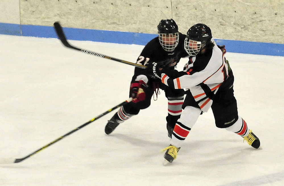 Maranacook’s Zack Davidson and Winslow’s Jake Larsen collide during game Wednesday at Sukee Arena in Winslow.